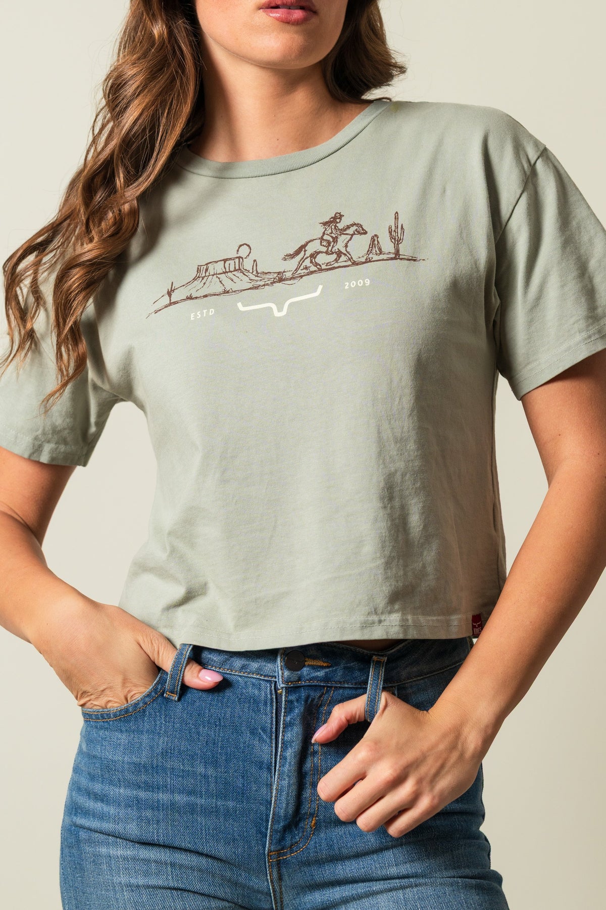 Kimes Ranch Go West sage short sleeve shirt with cowgirl and cactus graphic, 'ESTD 2009', and stylized steer logo; #color_sage