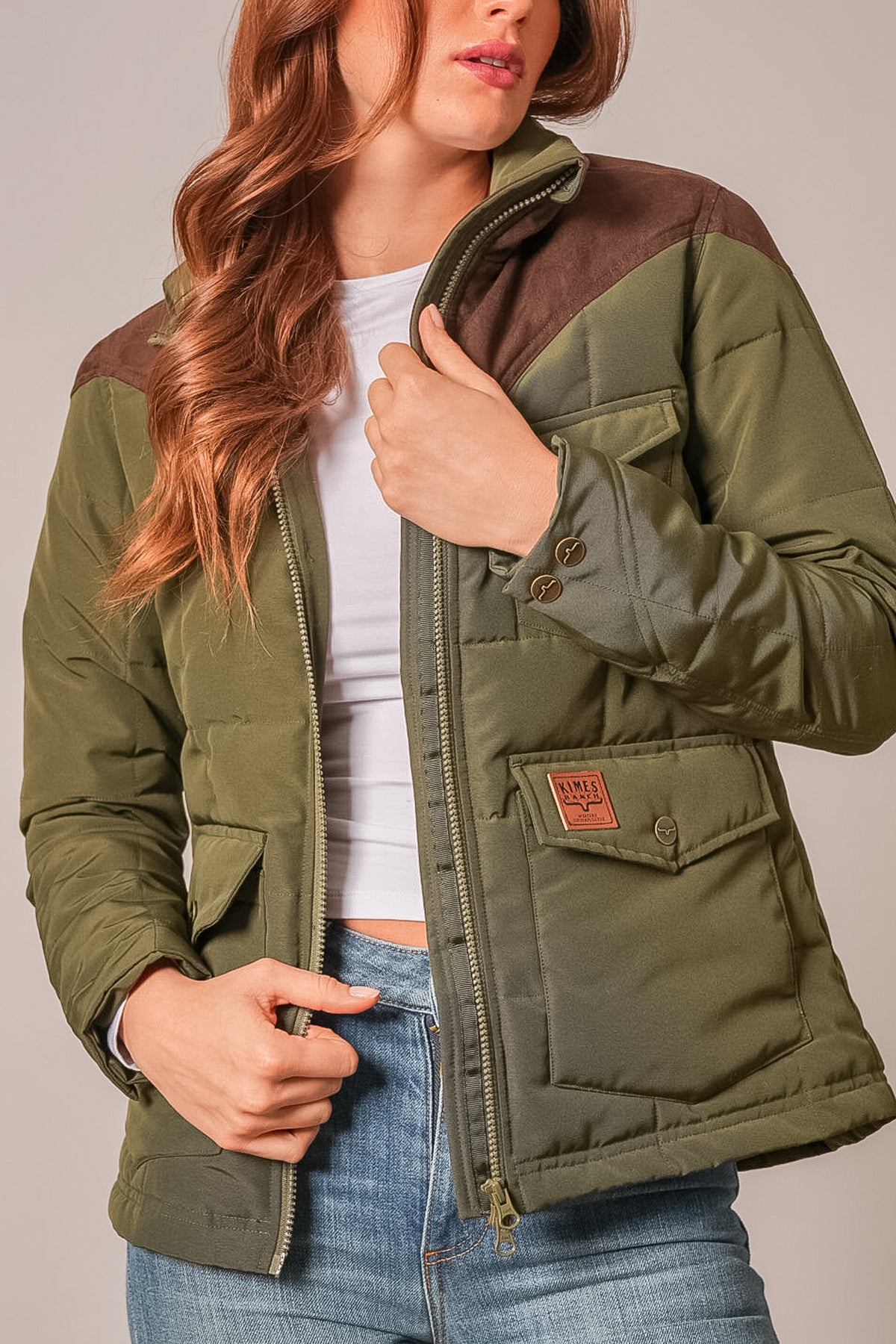 Kimes Ranch Lenora dark olive quilted jacket with brown yoke, front zip, buttoned flap pocket with logo