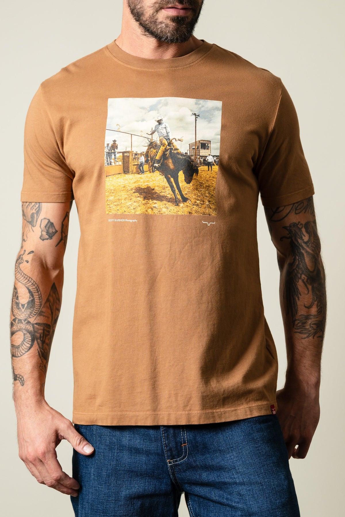 Kimes Ranch Tobacco SS Classic Event tee featuring a rodeo bull rider graphic with 'SCOTT SLUSHER Photography text; #color_tobacco