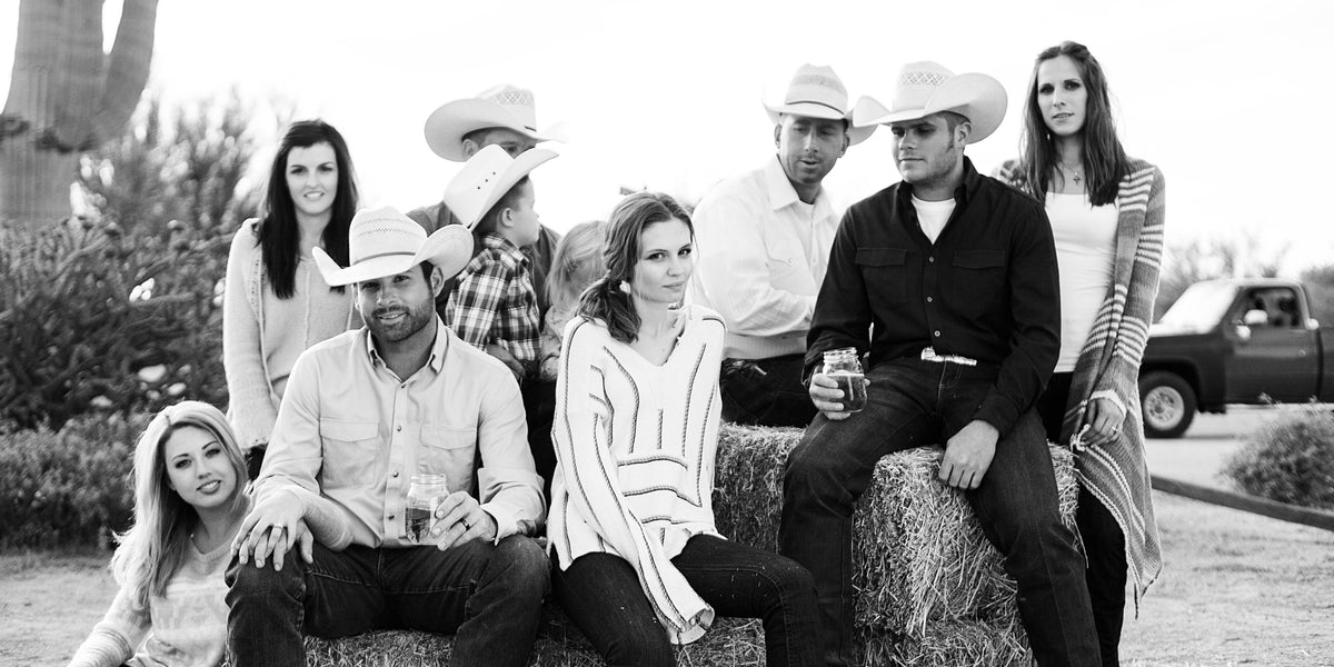 A group wearing Kimes Ranch Western apparel outdoors.