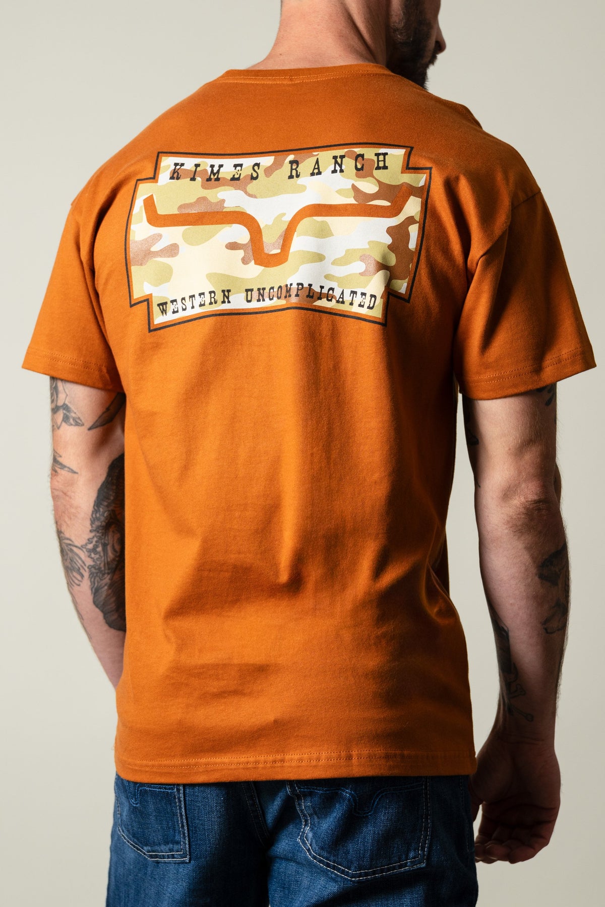 Kimes Ranch Clay Camo Crest men's T-shirt back view with Kimes Ranch and Western Uncomplicated graphic print; #color_clay