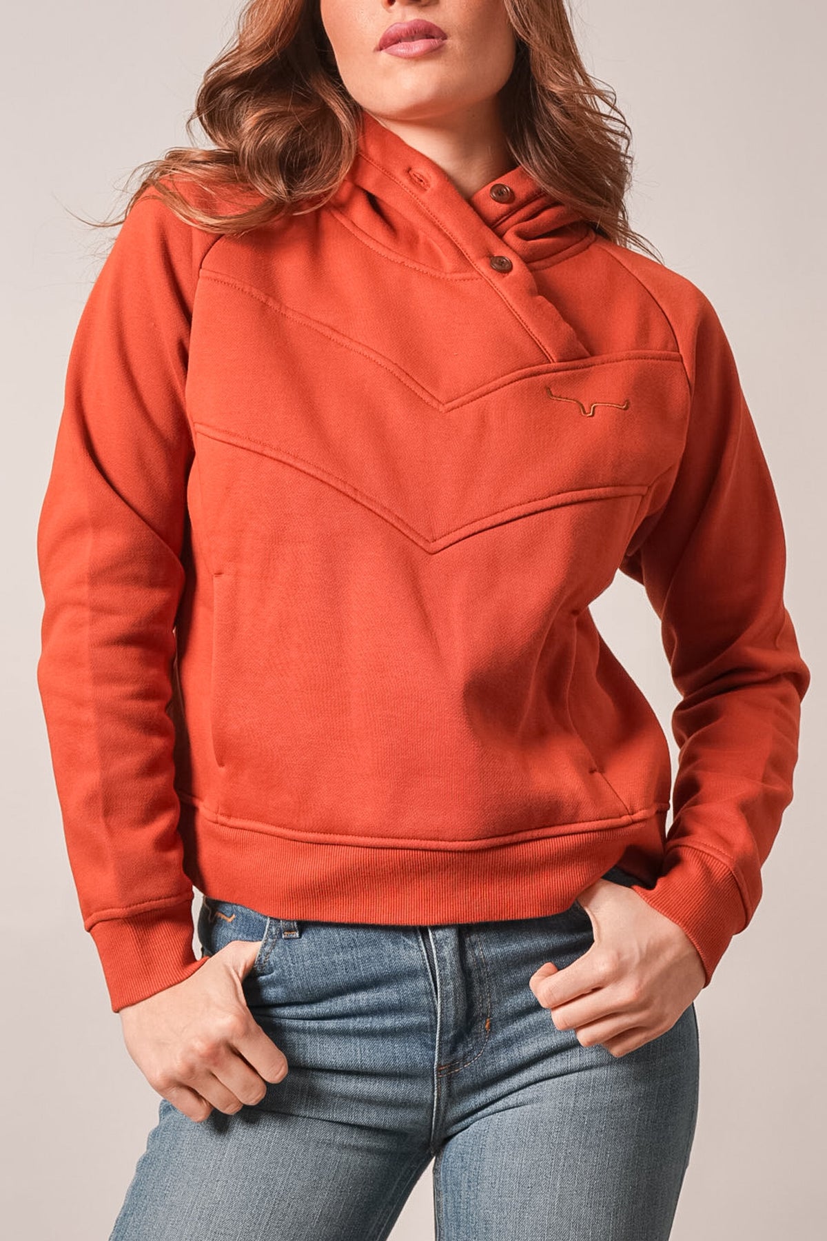 Kimes Ranch Ella hoodie in Burnt Red with long sleeves, a buttoned throat guard, and a chest Kimes Ranch logo