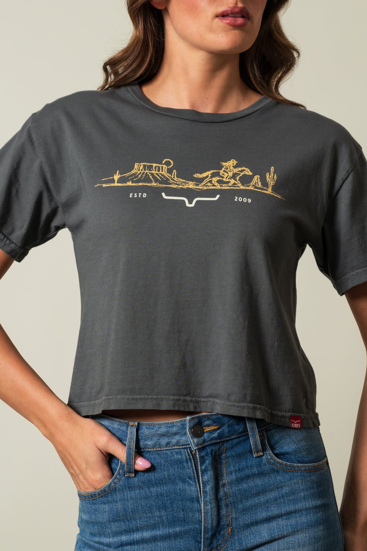 Kimes Ranch Go West shirt in Pepper, short-sleeved crewneck with a gold graphic of a western scene and Kimes Ranch logo; #color_pepper