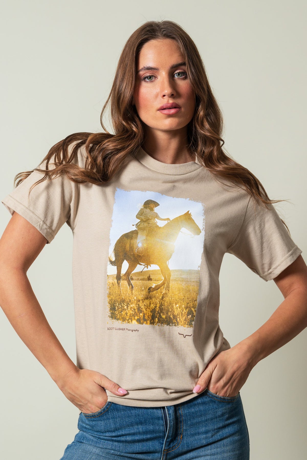 Kimes Ranch SS Riding Sunshine Sand t-shirt, featuring a graphic of a rider on a horse in a field; #color_sand